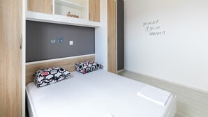 A modern bedroom with a bed, built-in shelving, and a motivational quote on the wall. - Apartment on Pag Island near Seabeach (Novalja)