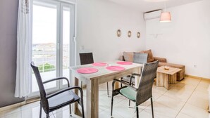 A dining area with a table, chairs, and a sofa. - Apartment on Pag Island near Seabeach (Novalja)