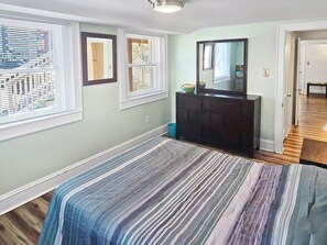 A bedroom with a bed, dresser, and windows. - Downtown 3 Bedroom gound level condo - 1 block from beach, boardwalk and Atlantic Ocean! Beach Roost (Ocean City)
