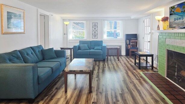 Un salon avec deux canapés bleus, une table basse en bois et une cheminée.
