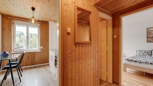 Un interior de madera con comedor, cocina y dormitorio.