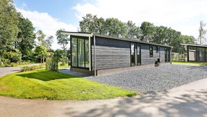 Un bâtiment moderne à deux étages, doté de grandes fenêtres et d’une allée gravillonnée.