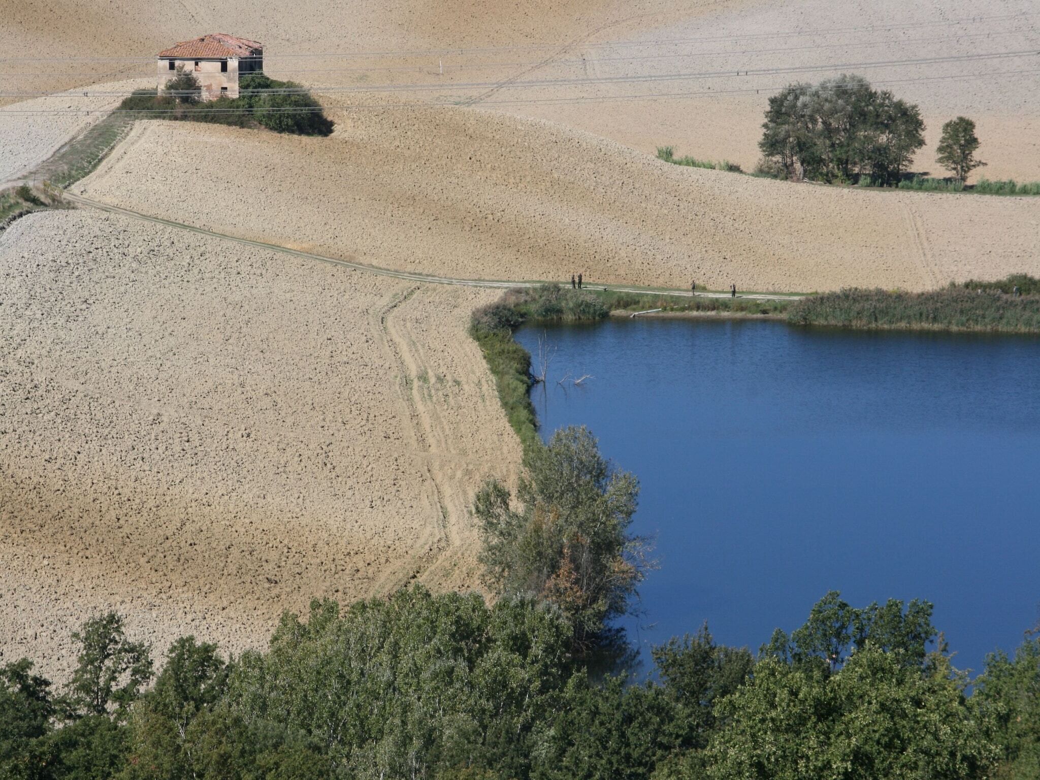A large, dry lakebed with a small building on a raised platform.