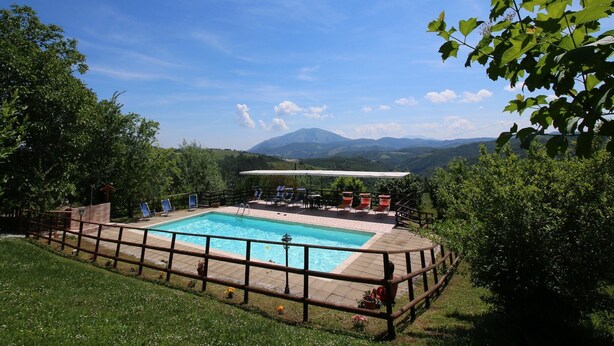 Une piscine rectangulaire dotée d’une terrasse en bois et d’une clôture en métal.
