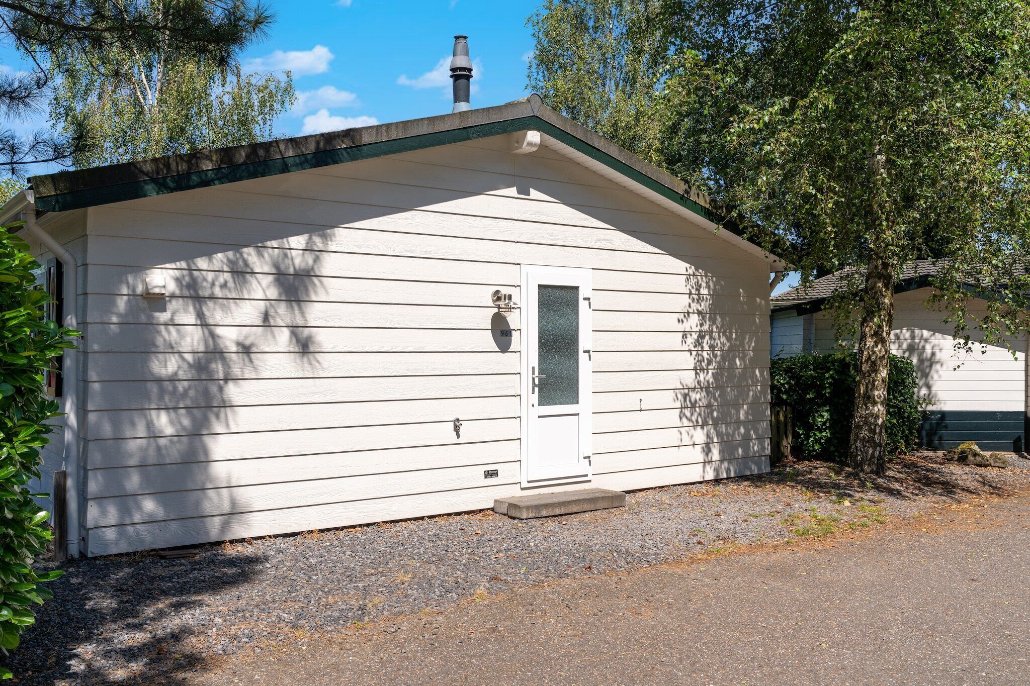 A small, single-story building with a white exterior and a dark roof.
