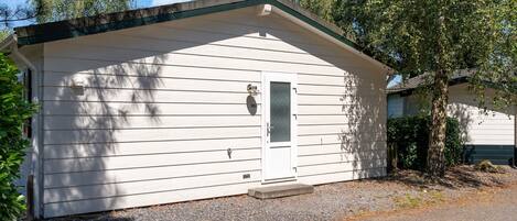 A small, single-story building with a white exterior and a dark roof.