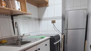 A compact kitchen with a sink, a dishwasher, and a refrigerator.