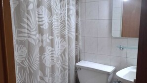 A bathroom with a toilet, sink, and shower curtain.