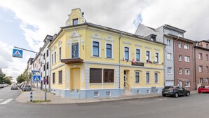 A yellow building with a sign indicating a hotel.