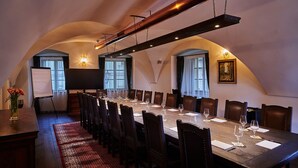 Una sala conferenze con un lungo tavolo, sedie e uno schermo per proiezioni.