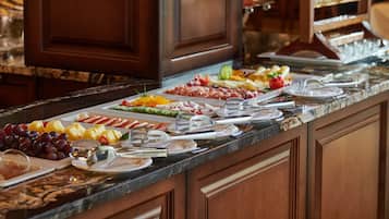 A buffet with various fruits, cheeses, and meats.