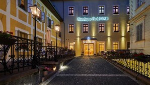 Un hotel boutique con un ingresso in pietra, elaborate ringhiere in ferro battuto e una facciata ben illuminata.