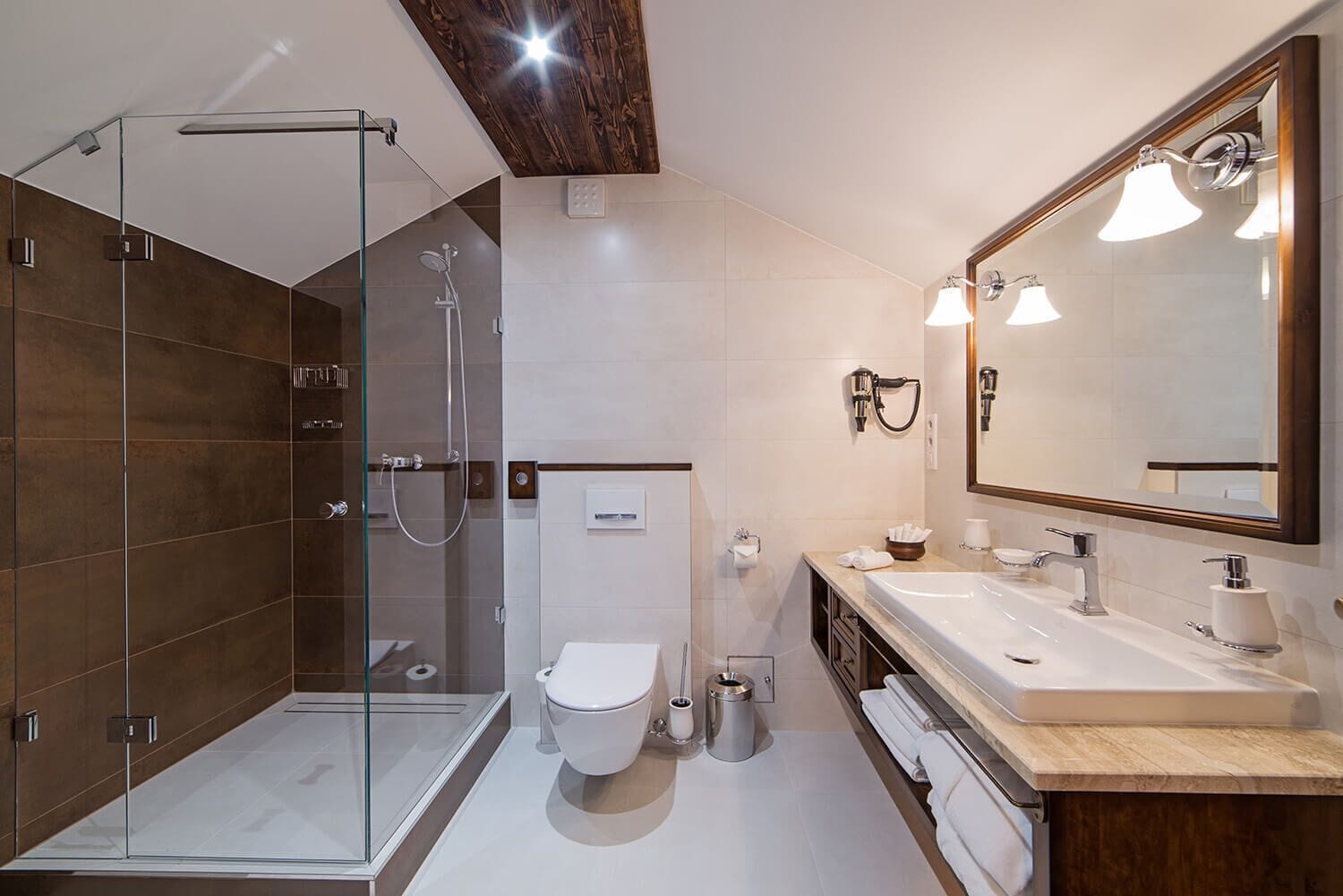 A modern bathroom with a glass-enclosed shower, a toilet, a sink with a mirror, and a towel rack.