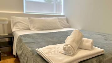 1 dormitorio, tabla de planchar con plancha, ropa de cama