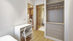 Un dormitorio moderno con escritorio integrado, vestidor y baño independiente.