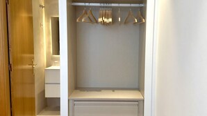 A walk-in closet with a hanging rod, a padded shelf, and drawers. - New Apartment Madrid Feria 103 (Madrid)