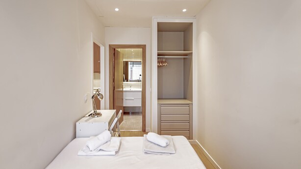 A hotel room with a bed, a bedside table, a mirror, a wardrobe, and a bathroom visible through an open door. - New Apartment Madrid Feria 103 (Madrid)