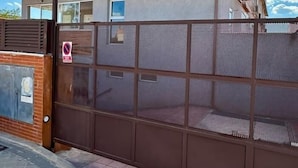 Un edificio de ladrillo de dos pisos con una reja metálica y una señal de prohibido el acceso.