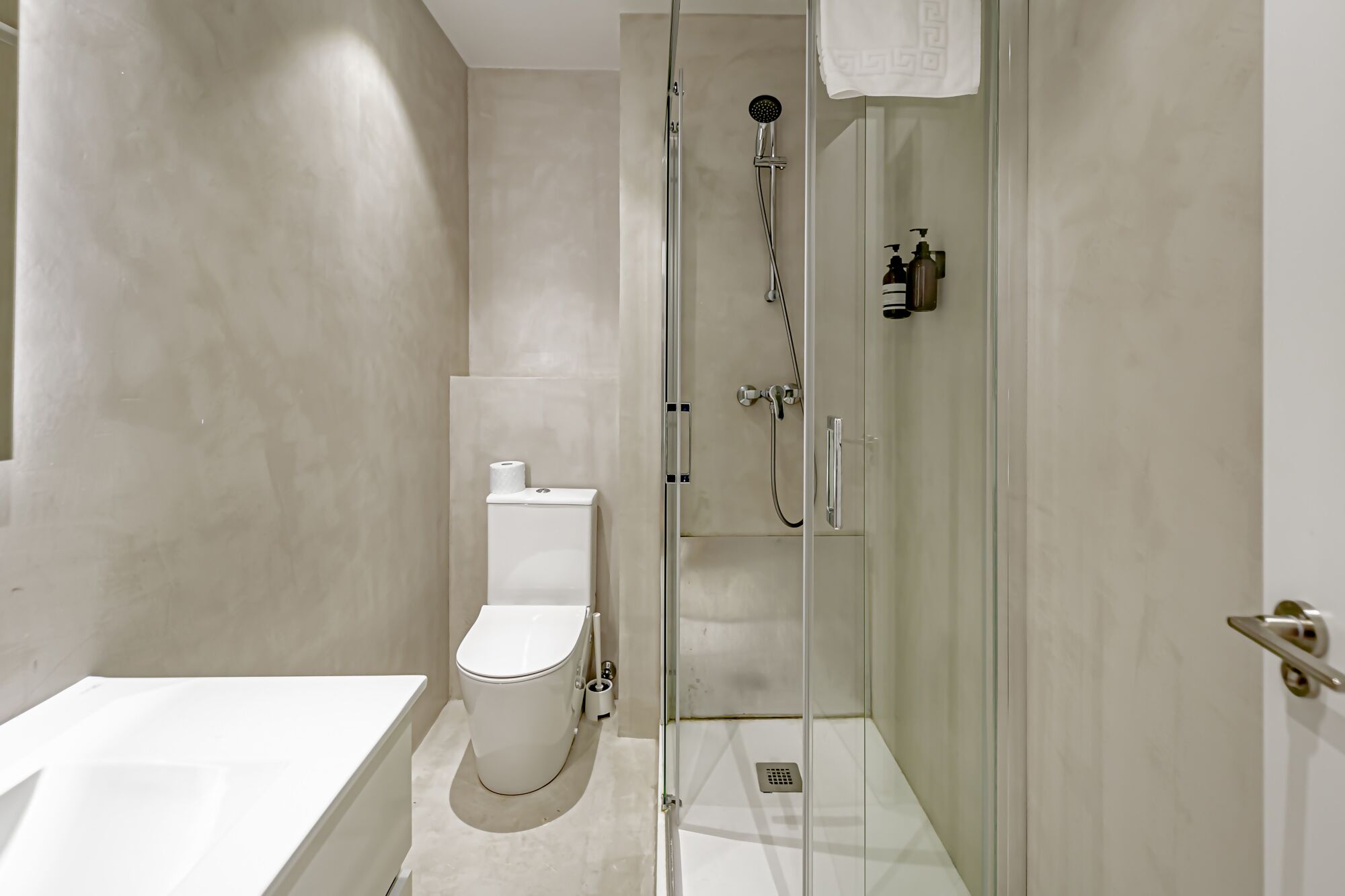 Un baño moderno con ducha acristalada, inodoro y bañera.