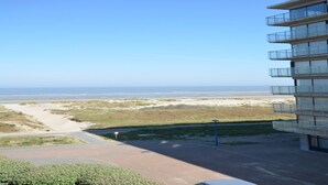 A view of a beach with a building in the foreground. - Coastal Retreat with Terrace (Oostduinkerke)