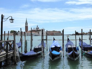 Gondolas docked at a pier with a historic building in the background. - Silea Apartments Pool Garden Treviso (Silea)
