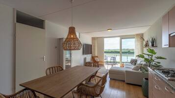 Een moderne keuken met een eethoek, een bank en uitzicht op de omgeving.