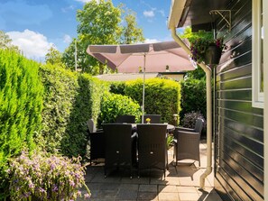 Relax in a serene outdoor space surrounded by lush greenery and a shaded seating area.
