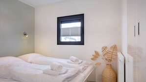 Ein Zimmer mit zwei Betten, einem Fenster, einer Heizung und einer Zierdevasse.