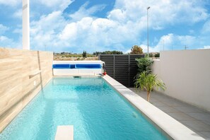 A swimming pool with a wooden deck and a view of the sky. - Villa in Rojales with Pool near Coast (Rojales)