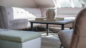 Een moderne woonkamer met een bank, een salontafel en een fauteuil.