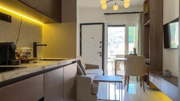 A modern kitchen with a built-in oven, a dining area with a table and chairs, and a view of the outdoors.