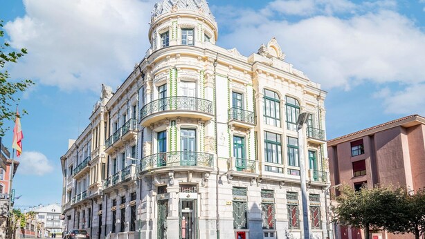Ein historisches Gebäude mit aufwendiger Architektur, mehreren Balkonen und einer markanten Kuppel.
