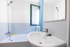 Een moderne badkamer met een bad, een wastafel en een douche.