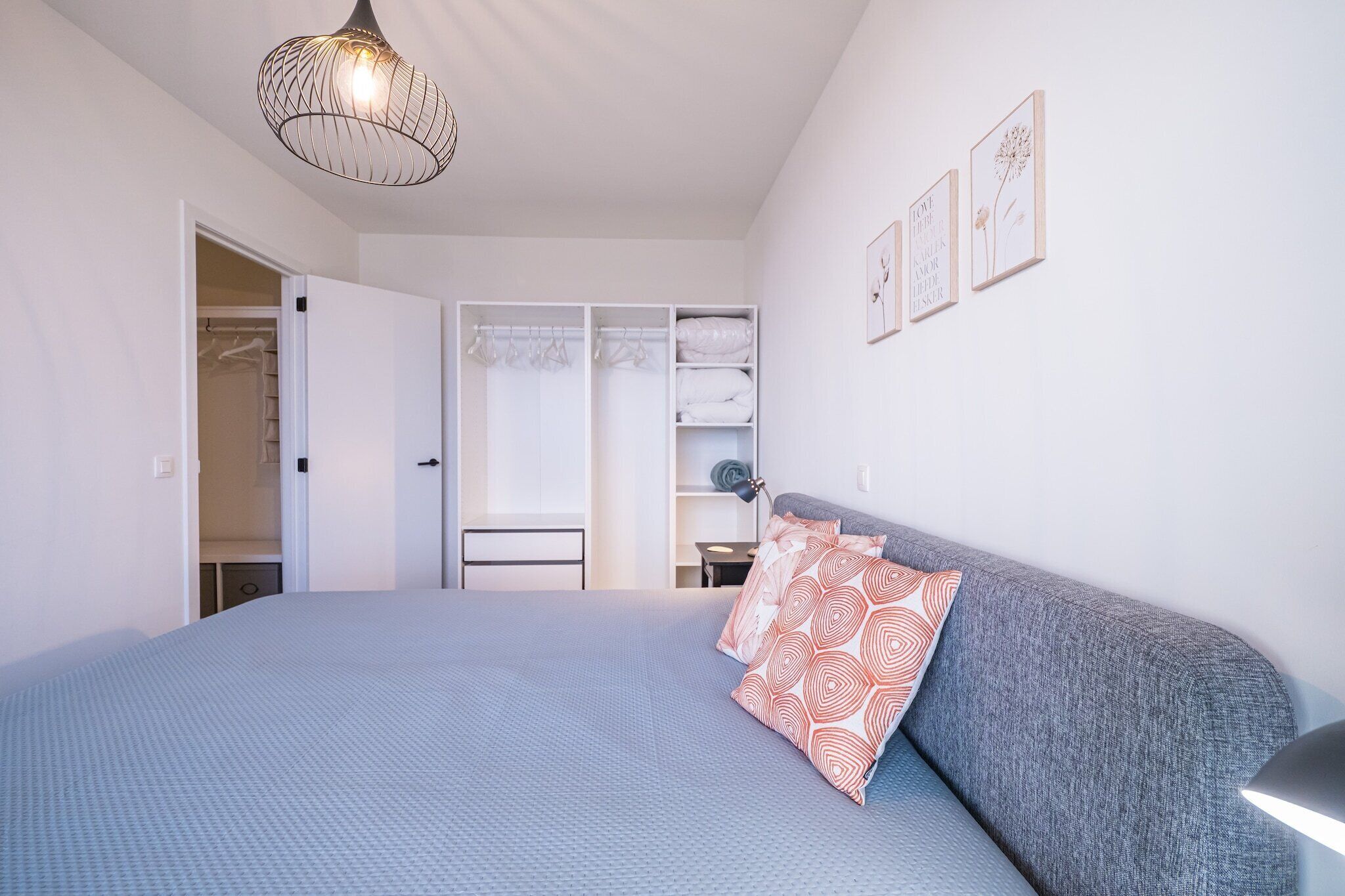 A bedroom with a bed, a wardrobe, and a desk.