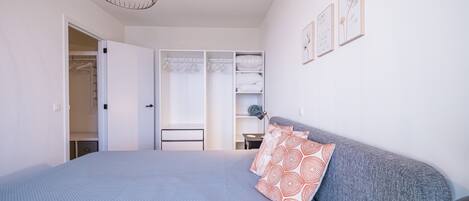 A bedroom with a bed, a wardrobe, and a desk.