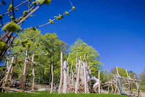 An outdoor sculpture garden with various abstract structures and trees in the background. - Appartement Elena mit Pool und Sauna (Freyung)