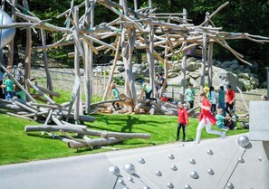 A playground with various climbing structures and a paved area with metallic spheres. - Appartement Martin mit Wellnessbereich (Freyung)