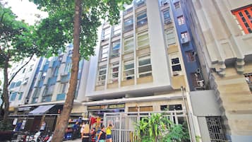 A multi-story building with a mix of residential and commercial spaces, including a visible storefront with signage.