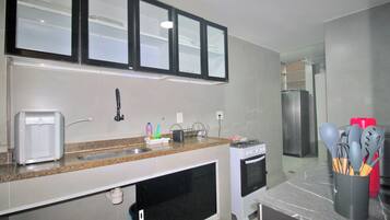 A kitchen with a toaster, sink, stove, and cabinets.