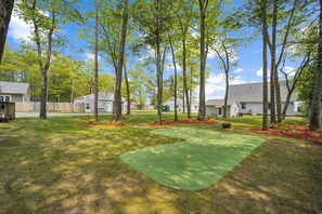 Un quartier résidentiel avec une pelouse verdoyante, des arbres et des maisons.