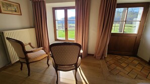 A room with two chairs, a radiator, and a window with curtains.