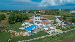 Une grande villa dotée d’une piscine, de plusieurs espaces de détente extérieurs et d’un jardin bien entretenu.