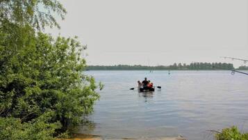 Ein ruhiger See mit einem kleinen Boot und Angelruten.