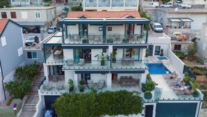 A multi-story residential building with a rooftop pool, balconies, and a garage.