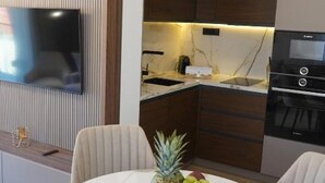 A modern kitchen with a built-in oven, microwave, and a dining area with a table set for two.
