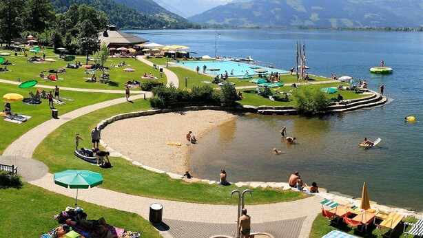 A lakeside resort with a swimming pool, sun loungers, and a boat rental area. - Apartment in Walchen near Ski Slopes (Piesendorf - Walchen)