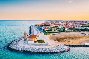 Eine Küstenstadt mit einer markanten Kirche, einem Strand und einem Steinsteg.
