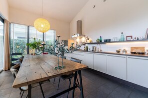 Enjoy meals at the dining table in this well-equipped kitchen with a view of the outdoors.