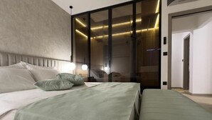 Een moderne slaapkamer met een groot bed, een inloopkast en een zichtbare badkamer.