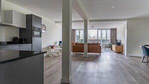 Un appartement moderne comprenant une cuisine, un coin repas et un salon.
